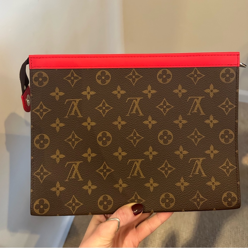 Louis Vuitton clutch with red trim. New with tag and verification.